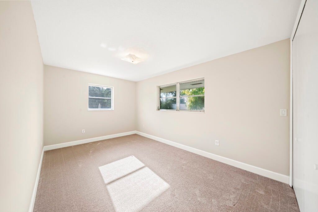 Bright bedroom with windows and hardwood flooring